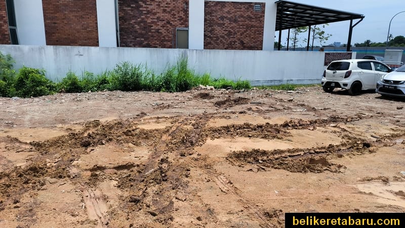 Tapak parking kereta dengan tanah merah yang baru dikambus menjadi lumpur selut akibat hujan lebat